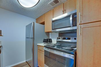 Kitchen with a stove, microwave, and refrigerator